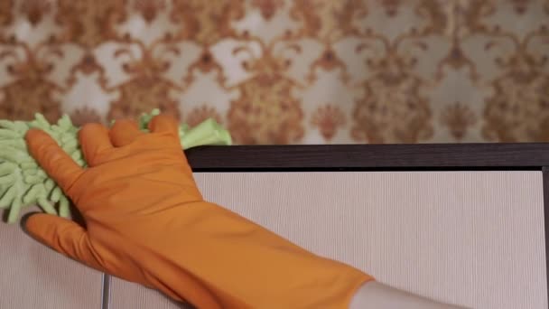 Mano femminile in gomma arancione guanti pulisce una superficie di legno con microfibra Rag — Video Stock