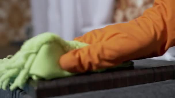 Kvinnlig hand i gummi Orange handskar torkar en träyta med Microfiber Rag — Stockvideo