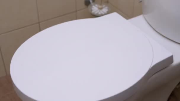 Female Hand Puts a Roll of Toilet Paper on Toilet White Lid. 4K — Stock Video