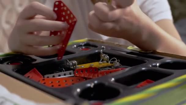 Meraklı Çocuk Evdeki Masa 'da Yapıcı Metal Parçaları ile oynuyor. 4K — Stok video