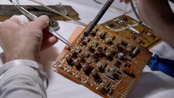 Människan lödmetall Transistorer, Radio delar på elektronisk kartong med lödmetall — Stockvideo