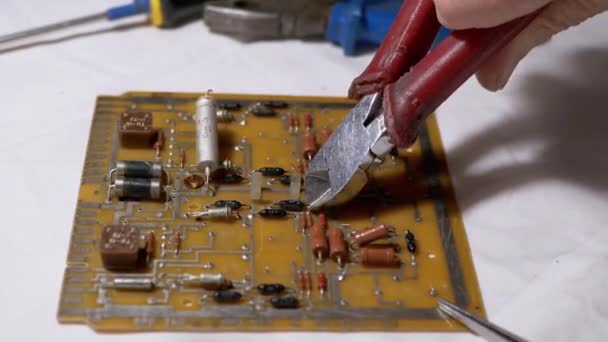 Master with Wire Cutters Disconnecting Radio Parts, Resistors from Board, Scheme — Stock video