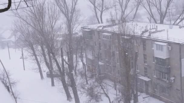 Silná zimní sněhová bouře, sněžení na nádvoří staré vícepodlažní budovy. 4K — Stock video