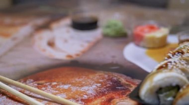 Plastik kutuda Japon suşi ruloları Restoran Masasında servis edilir. 4 bin. Yakın plan.