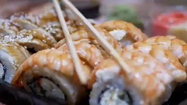 Rollos de Sushi Japonés Camarones en Caja de Plástico a Servido en Mesa con Palos de Bambú — Vídeos de Stock