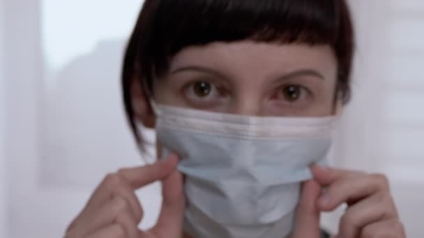 Mladá žena v masce otočí červenou, krvavé oči. Virová konjunktivitida. 4K — Stock video