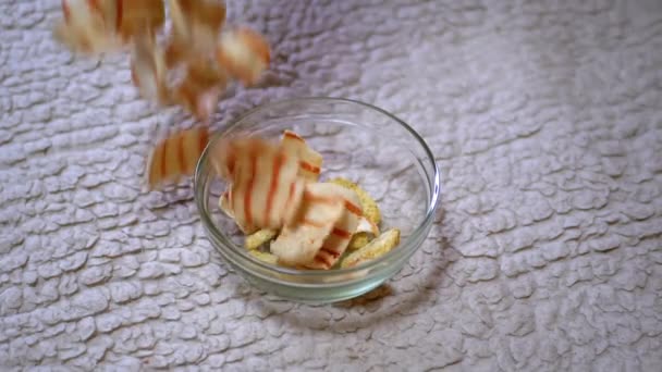 З "являються смажені чіпси Кріспі Карто, які падають у скляну тарілку і стіл — стокове відео