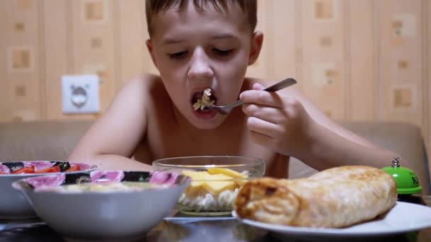 Голодный ребенок ест пасту вилкой. Домашняя еда. Концепция быстрого питания в домашних условиях — стоковое видео