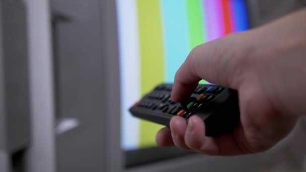 Γυναικείο χέρι που χρησιμοποιεί τηλεχειριστήριο TV προσπαθεί ένα διακόπτη SMPTE χρώμα μπαρ πρότυπο δοκιμής — Αρχείο Βίντεο