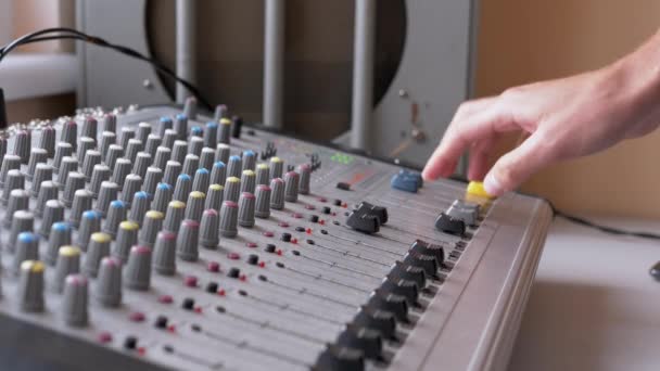 Sound Engineer, DJ beweegt schuifregelaars met vingers op audio mixer in de opnamestudio — Stockvideo