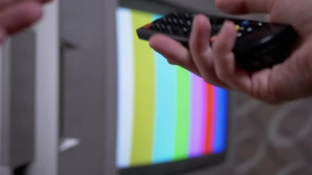 Mano femenina usando TV control remoto intenta un patrón de prueba de barras de color SMPTE interruptor — Vídeos de Stock