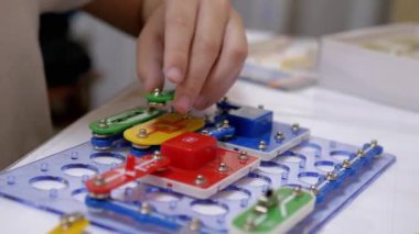 Meraklı Çocuk Metal İnşaat Malzemeleri Elektrik Devresini Birleştiriyor. Büyüt