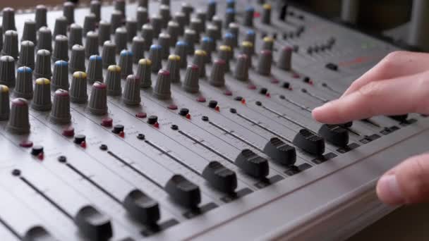 Sound Engineer, DJ beweegt schuifregelaars met vingers op audio mixer in de opnamestudio — Stockvideo