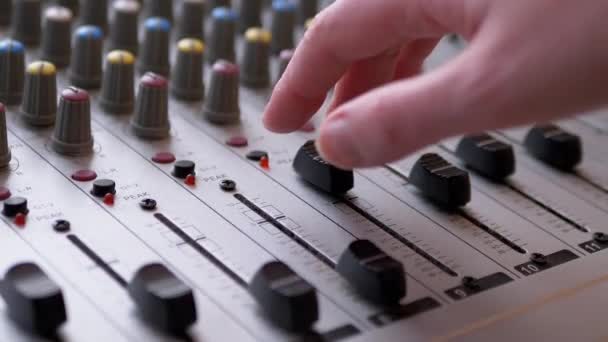 Tontechniker, DJ bewegt Schieberegler mit den Fingern am Audio-Mischpult im Tonstudio — Stockvideo