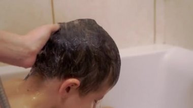 Kadın Eller Çocuk Kafasını Banyo 'da Sıcak Su Deresi Altında Duruladı. 4K