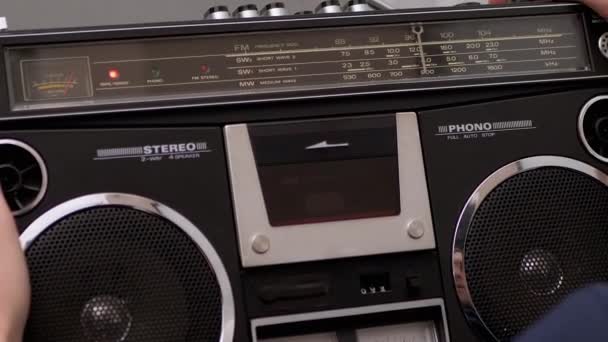 Varón sostiene grabadora de cinta de audio vintage en las manos con cassette de audio giratorio — Vídeos de Stock