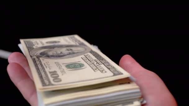 Manos masculinas Scatter Pila de 100 dólares estadounidenses facturas sobre fondo negro. Dinero. 4K — Vídeos de Stock