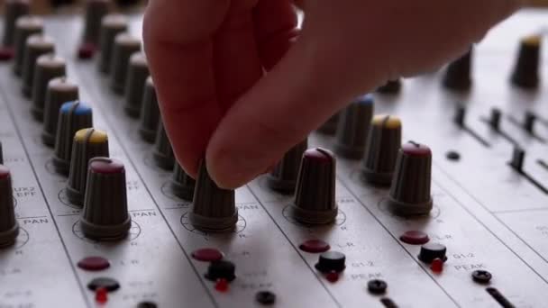 Sound Engineer, DJ beweegt schuifregelaars met vingers op audio mixer in de opnamestudio — Stockvideo