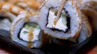 Bambu Çubuklu Suşi Ustası Suşi Yuvarlamasını Plastik Kutuya Bürüyor. Büyüt