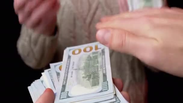 Мужские руки Scatter стек 100 долларов США счета на черном фоне. За деньги. 4K — стоковое видео
