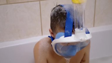 Çocuk köpükle yıkanır, maskenin altından su çıkarır. Dalış Öğrenme