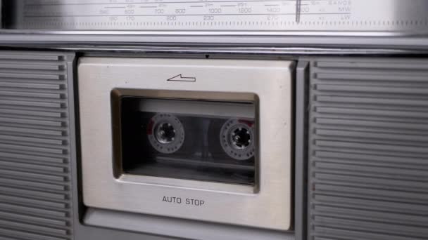 Женщина вращает старую прозрачную кассету, взятую из винтажного магнитофона — стоковое видео