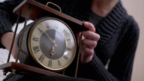 Mains féminines Ajuster l'horloge de table en bois mécanique avec chiffres romains dans Rétro — Video