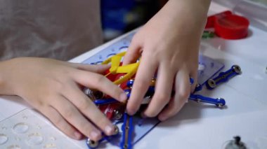 Meraklı Çocuk Evdeki Masa 'da Elektronik Metal İnşaatçısıyla Oynuyor. 180fps