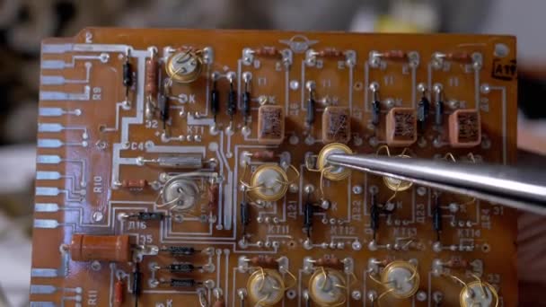 Radiotechnicus demonstreert kostbare radiotransistors op een elektronisch bord — Stockvideo