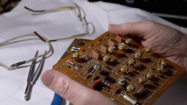 Técnico de radio examina preciosos transistores de radio, en un tablero electrónico. — Vídeo de stock