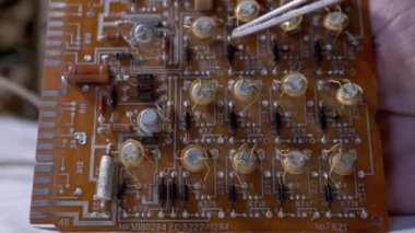 Radyo teknisyeni, değerli radyo transistörlerini bir elektronik kurulda gösteriyor.