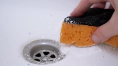 Kadın eli, Orange Sponge ile lavabodaki tıkanıklığı kaldırdı. 4 bin. Yakın plan.