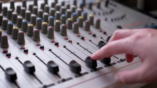 サウンドエンジニア、 DJはレコーディングスタジオでオーディオミキサー上の指でスライダーを移動します — ストック動画