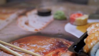 Plastik kutuda Japon suşi ruloları Restoran Masasında servis edilir. 4 bin. Yakın plan.