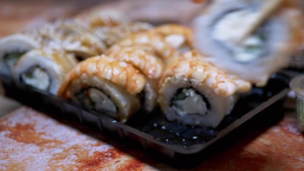 Sushi Master met Bamboe Sticks Verspreidt Sushi Rollen in een Plastic Box. 4K — Stockvideo