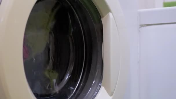 Színes ruhák mosása a háztartási mosógépben. Forgó dob. Nagyítás — Stock videók