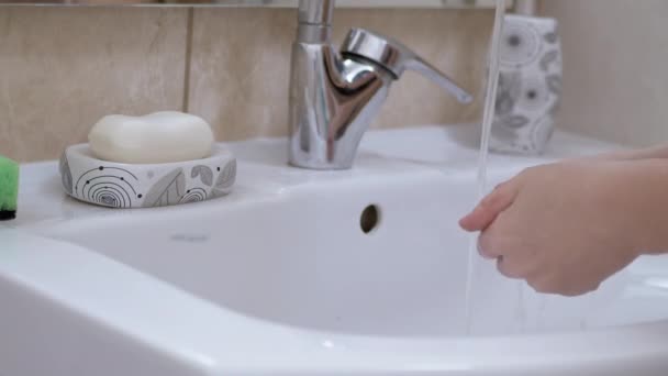 Woman in Front of Mirror Turns Onwater Tap and Washes Hands liquid Soap. 4K — Stock Video