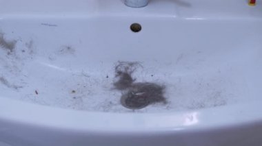 Lavabo saç, yün ve enkazla tıkanmış. Kanalizasyon tıkanması. Büyüt
