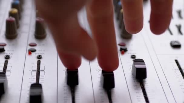 Звуковий інженер, DJ переміщує повзунки з пальцями на аудіомікшер у студії звукозапису — стокове відео