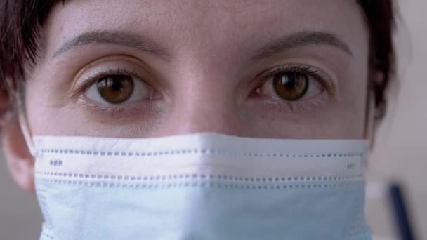 Chica joven con máscara gira rojo, ojos de bala de sangre. Conjuntivitis viral. Zoom: — Vídeos de Stock