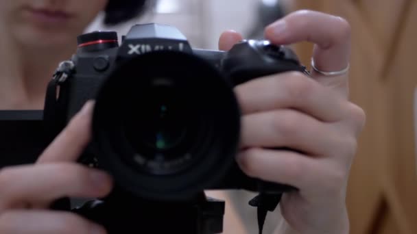 La mujer ajusta el enfoque manualmente en una cámara moderna, nueva, videocámara. Lente de cámara. 4K — Vídeos de Stock