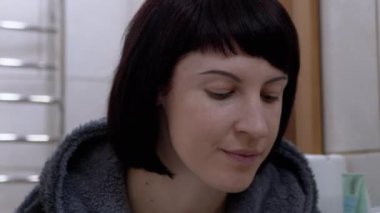 Kadın, Ayna Önündeki Korece Yamalar kullanarak Gözlerin Etrafındaki Kuru Cildi Nemlendiriyor