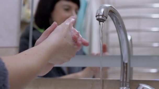 Mulher ativa torneira de água e lava as mãos sabão líquido com espuma. Borrão. 4K — Vídeo de Stock