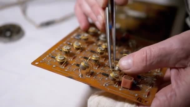 Master, Using Tweezers, Inserts Radio Parts, Transistors in Board, on Scheme. 4K — Stock Video