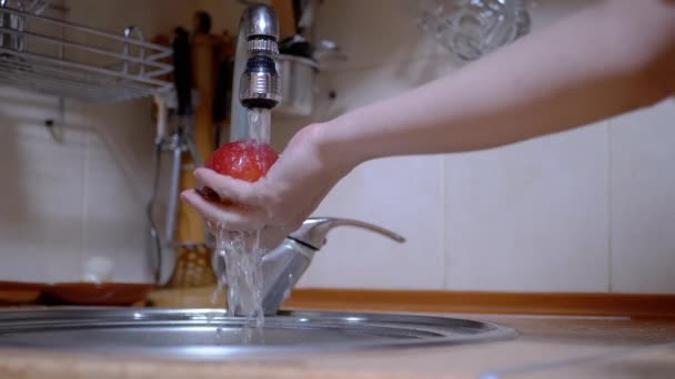 Mãos femininas lavando uma maçã madura e vermelha com água corrente da torneira — Vídeo de Stock