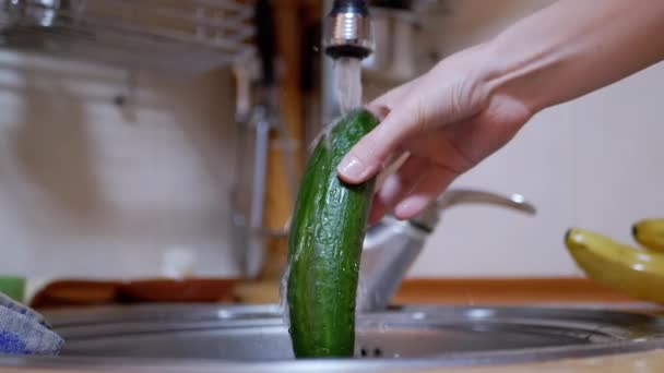 Female Washing Green Cucumber with Running Water from a Tap in a Modern Kitchen — Stock Video