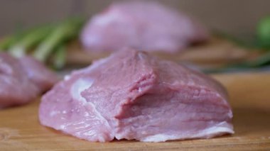 Kadın El, kesme tahtasındaki bir parça taze çiğ eti yerden kaldırıyor. 4K
