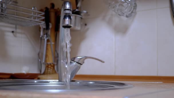 Corriente de agua que corre Vierte desde el grifo en el fregadero de la cocina. Grifo abierto — Vídeo de stock