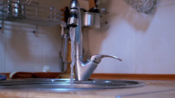 蛇口から台所のシンクに注ぐ水の流れを急いでください。開いたタップ — ストック動画