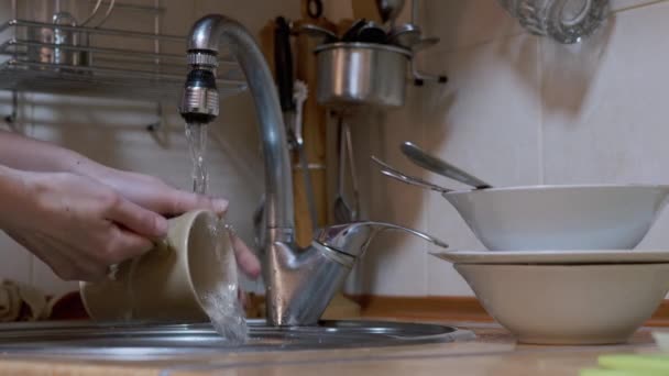 Kvinnliga händer Tvätta rätter, keramiska koppar, tallrikar i diskbänk ett rinnande vatten. 4K — Stockvideo